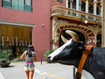 Jeune fille au chandail rayé et statue de taureau en face du Pa