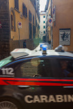 Une voiture de carabiniers passe à toute vitesse devant un jeun