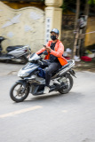 Motocycliste avec un cellulaire roulant dans une rue de Hanoi, V