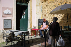 Un propriétaire de restaurant discutant avec une passante.