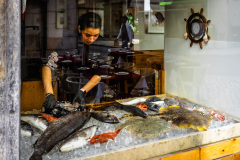 Une employé d'un restaurant préparant le poisson.