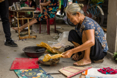 Femme cuisant un galette de riz souflés cuit sur braises au mar