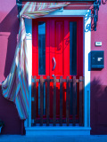 Une porte rouge brille de tous ses feux sur cette façade d'une