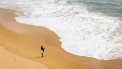 Jeune femme photographiant la mer è la Plage de Carreiro da Faz